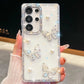 Phone case with butterfly and pearl designs held by a hand, white case