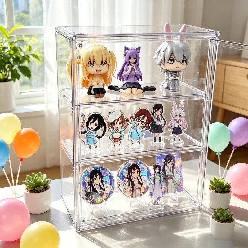 A clear acrylic three-tier display box filled with anime figurines and round character prints, styled on a bright windowsill with balloons, potted succulents, and soft natural light.