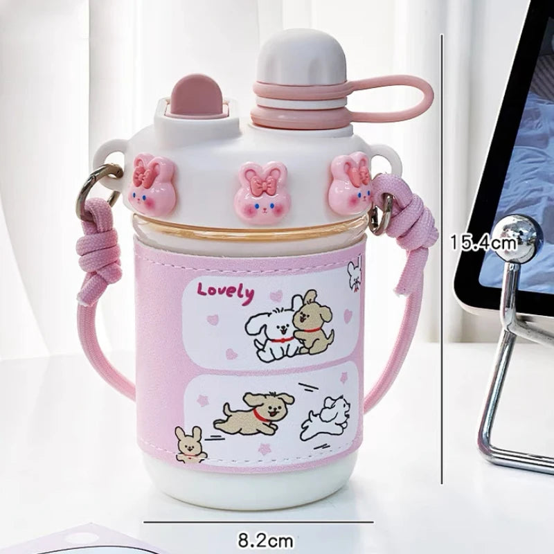  cute water bottle with cartoon designs held by hands against a blurred background. displaying the measurements of it.