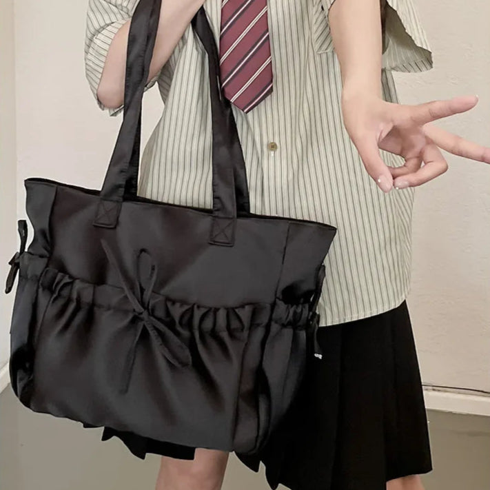 Person wearing a striped shirt and tie with a large black bag.