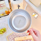 Metallic bowl held by a hand on a kitchen counter with a blurred background