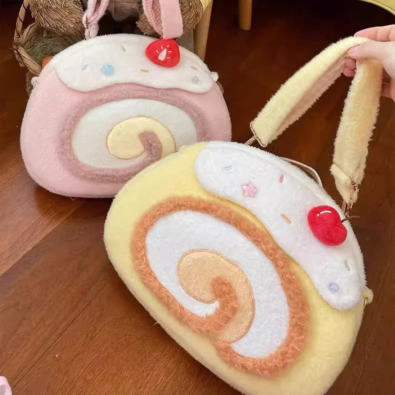 Two plush kawaii bags shaped like swiss rolls on a wooden floor.