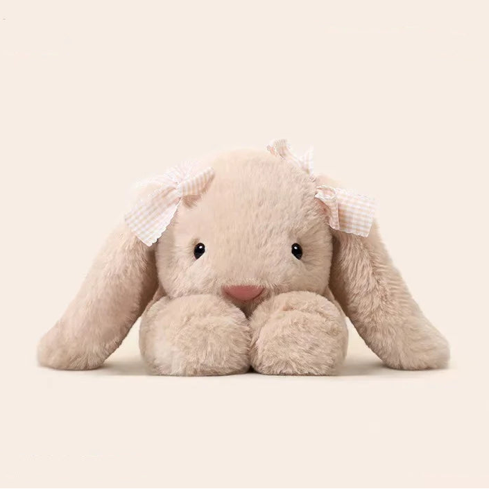 Kawaii bunny plushies with a bow on a beige background.
