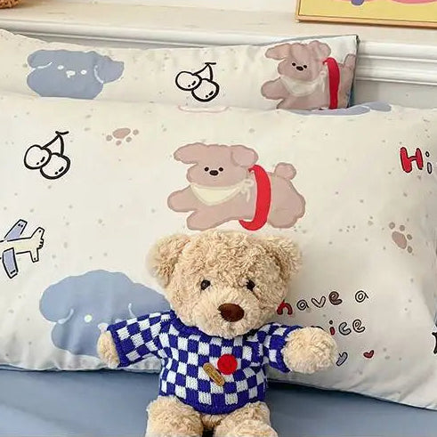 Children's pillow with teddy bear design and cartoon elements on a bed.