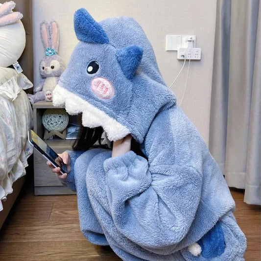 Person wearing a blue shark hoodied onesie in a room.