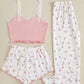 Set of pink and white pajama top, shorts, and pants with floral pattern on a beige background