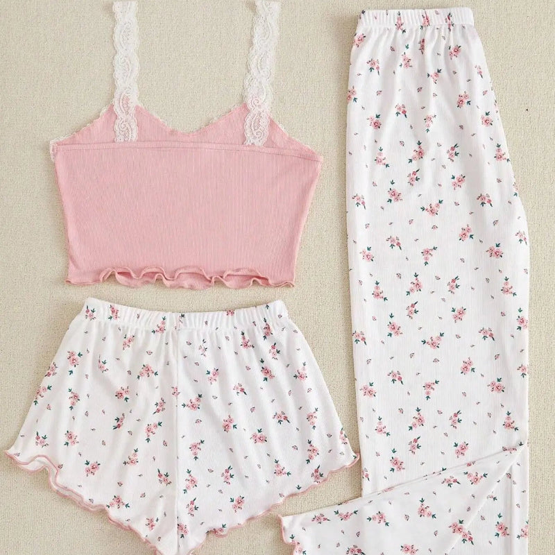 Set of pink and white pajama top, shorts, and pants with floral pattern on a beige background