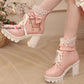 Pink platform shoes with bow and star decorations on a neutral background