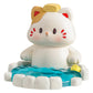 Cute resin figurine of a cat in a onsen with a yellow towel on its head on a white background.