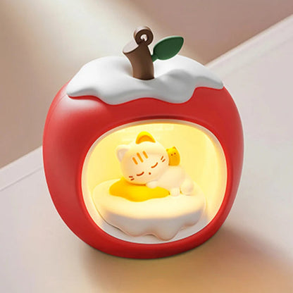 Red apple-shaped night light with a Kawaii sleeping cat design inside, on a neutral background.