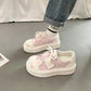 cute cat Pink sneakers worn with light-colored pants on a neutral background
