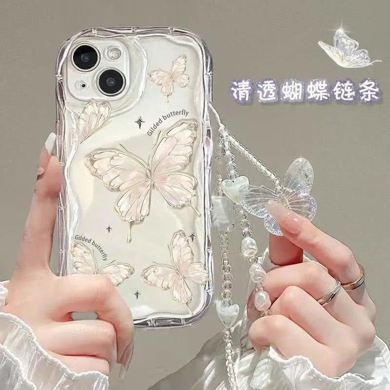 Phone case with butterfly design held by a person, featuring a chain.