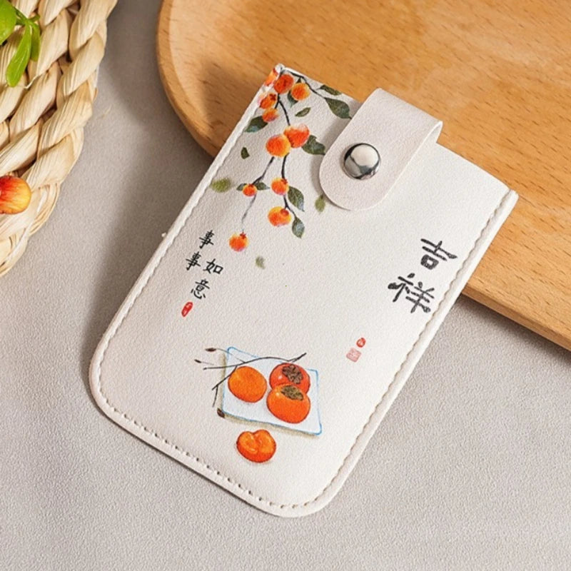 White cardholder with orange design on a wooden surface