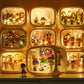 A collection of retro-style glowing display boxes containing many small colorful figurines, arranged on a shelf. The boxes are illuminated from within, creating a warm golden glow, with one larger box in front and smaller boxes behind it.