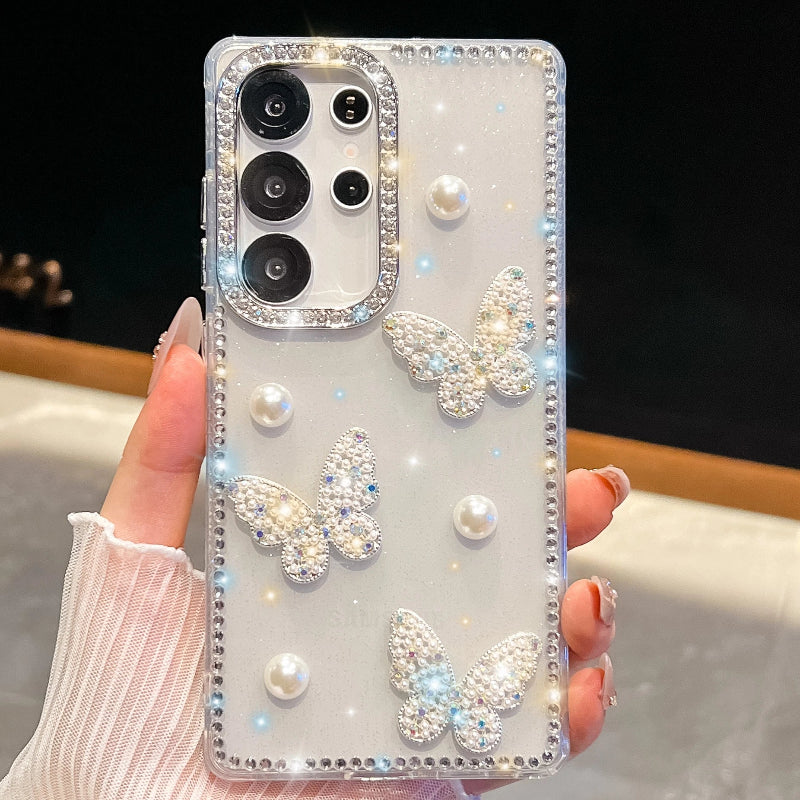 Phone case with butterfly and pearl designs held by a hand, case is white