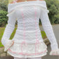 Front view of a Kawaii Coquette Off Shoulder Ribbon Sweater modeled by a woman in white 