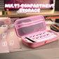 Pink multi-compartment storage case on a desk with electronic accessories.