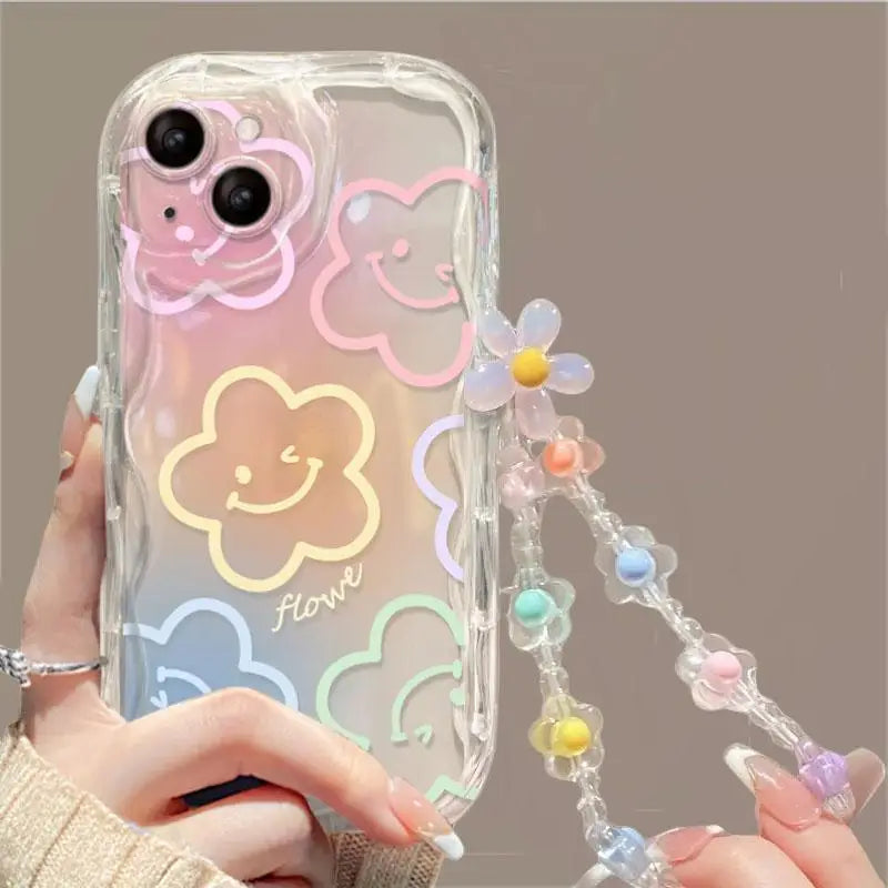 Clear phone case with floral designs and a strap held by a person.