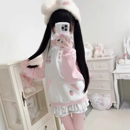 Person wearing a cute outfit with a white and pink theme in a room.