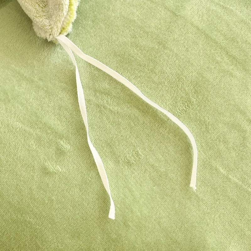 Close-up of a green fabric with a white drawstring on a matching green background