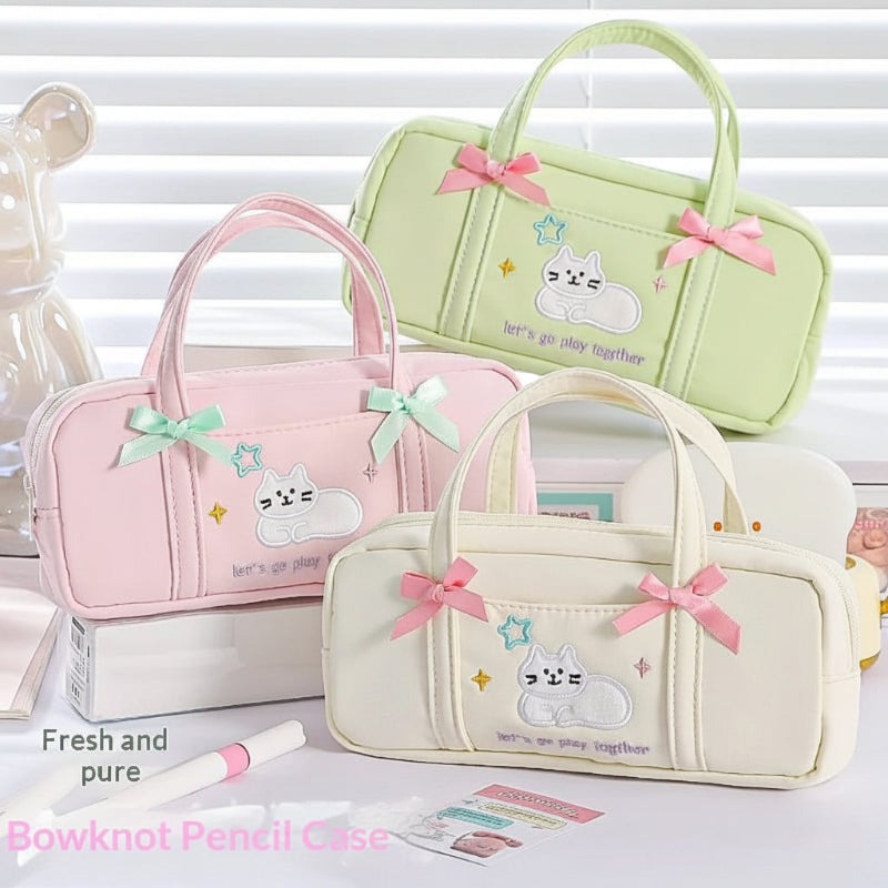 Three cute pencil bags with cute cat designs and pink bows on a white background.