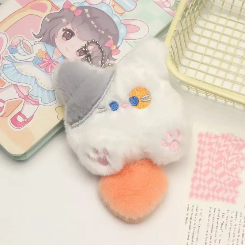 Plush keychain with a cute design on a surface with a card and basket in the background