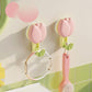 Pink and green petal hooks on a tiled wall with Dopamine branding.