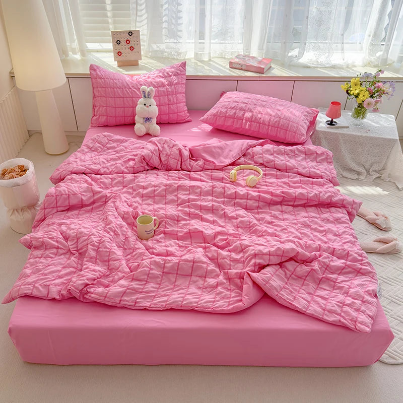 Pink  seersucker duvet set displayed on bed.