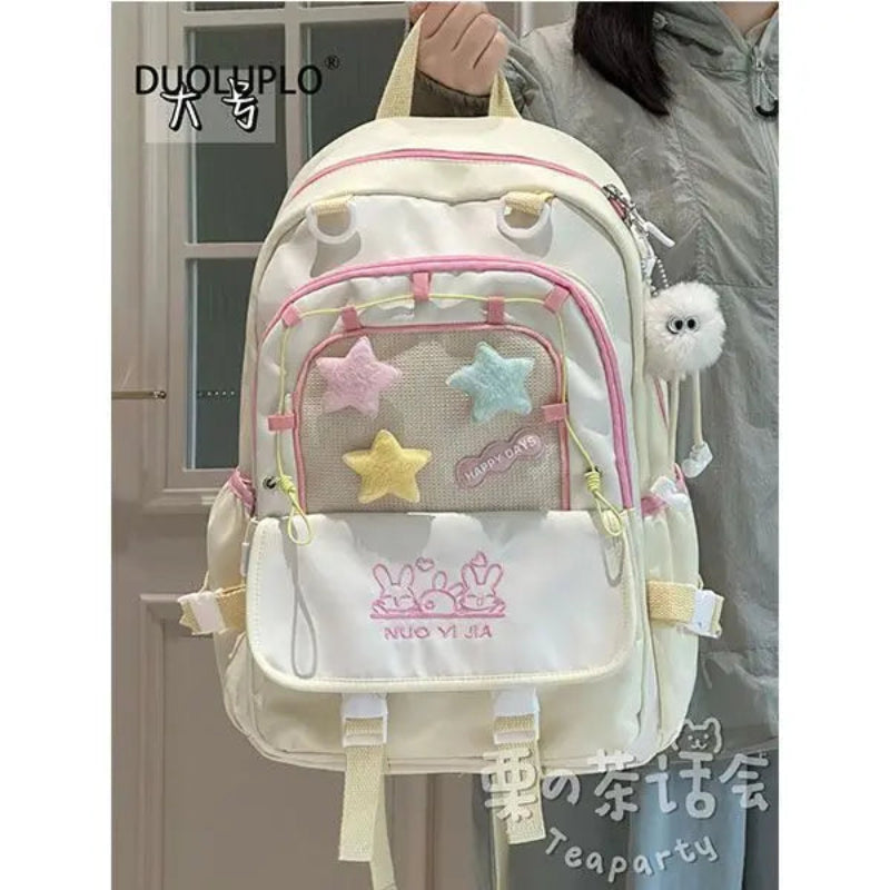 Kawaii backpack with star designs being held by a person