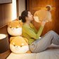 Woman sitting on a bed holding a large plush dog toy, surrounded by similar plush toys.