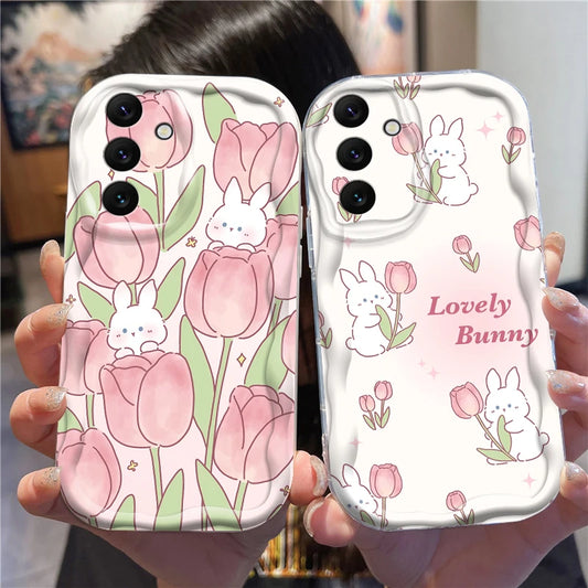 Two phone cases with floral and bunny designs held by a person.