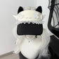 Black visor cap with white accents and decorative elements on a mannequin head with white hair.
