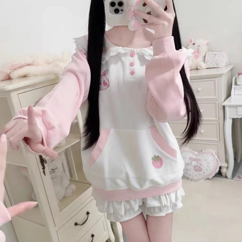Person wearing a kawaii pink and white outfit with matching accessories in a room.