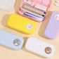 Colorful pencil cases with cartoon bear faces on a beige surface
