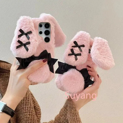 woman isholding the Kawaii Plush Bunny Samsung Phone Case to display the back of the case , showing off the floppy pink bunny ears.