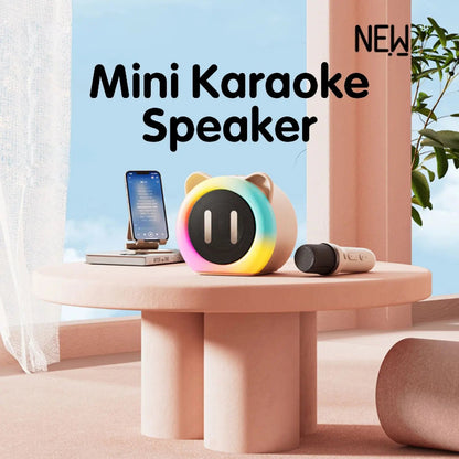 Cute Cat Mini Karaoke Speaker pink edition displayed on a pink table top with a microphone and phone next to it.