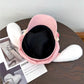 Pink bunny hat upside down on a wooden table