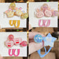 Set of colorful hair accessories including clips and rubber bands on GG&MM branded cards.