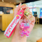Pink keychain with a character charm held in a hand indoors.