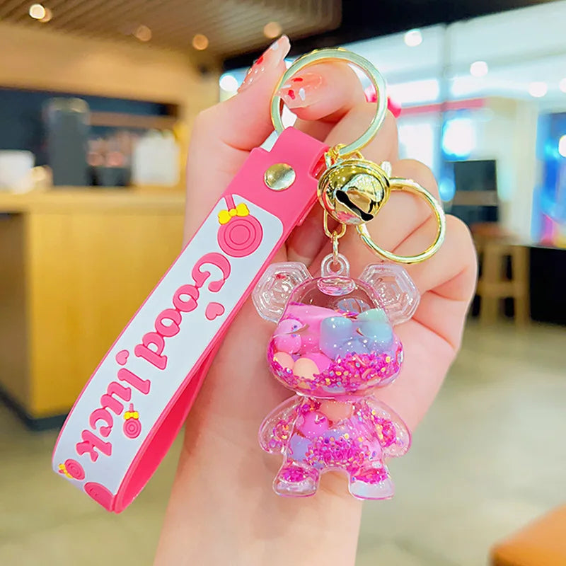 Pink keychain with a character charm held in a hand indoors.