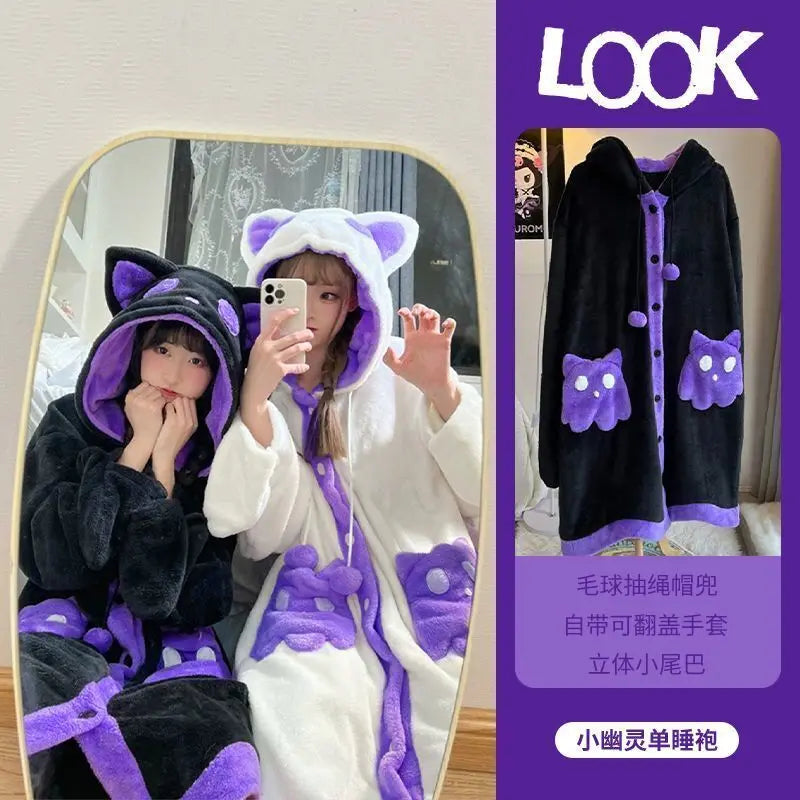A plush hooded robe with cat ears and purple accents, shown both on a model taking a mirror selfie and as a standalone product image. The robe has a black and white body with purple trim, ear tips, and paw-print details on the front and hood.