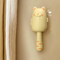 Cat-shaped lint roller on a beige background