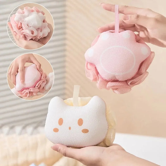Pink cat-shaped sponge with a hand holding it, set against a neutral background.