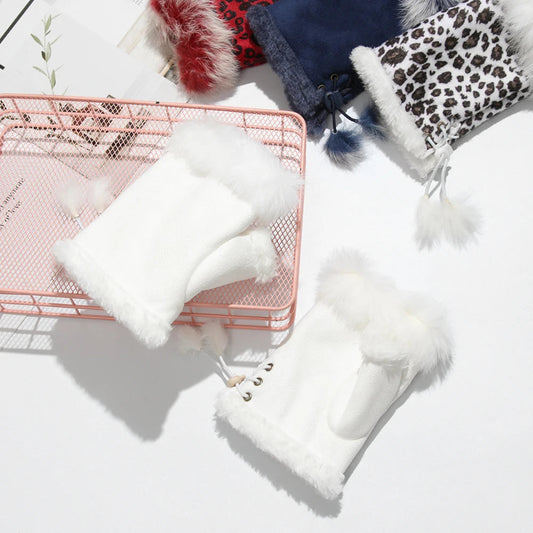 White furry fingerless gloves on a white surface with a pink wire basket.