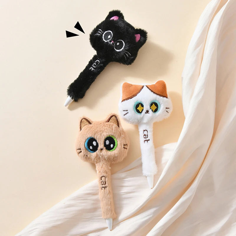 Three cat-shaped pens on a beige fabric background