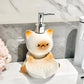 Cat-shaped soap dispenser on a marble countertop with a floral arrangement.