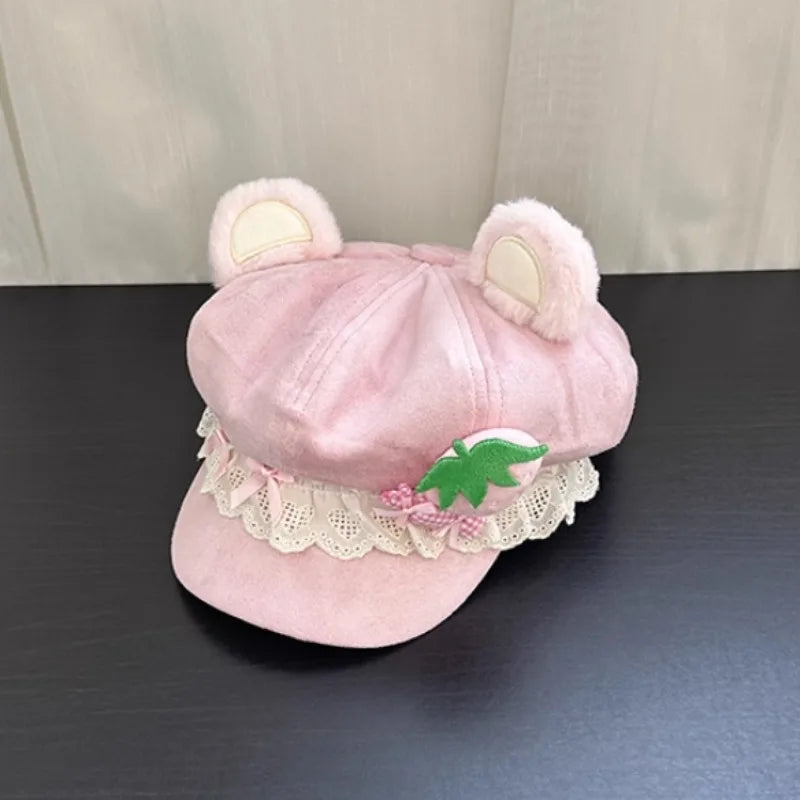Pink kawaii hat with bear ears and lace details on a dark surface