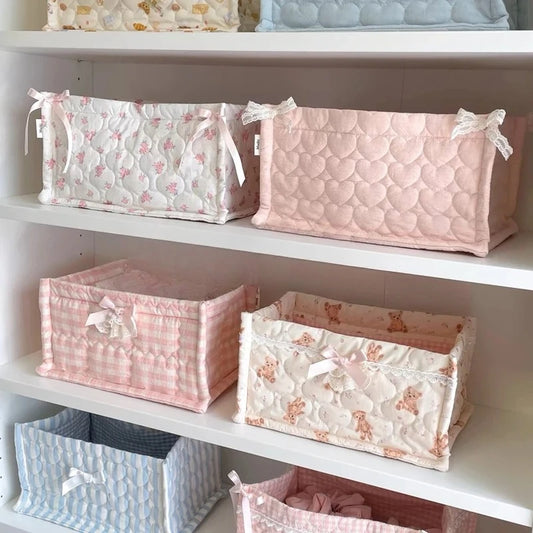 Set of pink and white patterned storage baskets on a shelf.
