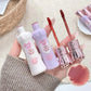 Lip gloss set with decorative packaging held by a person, on a neutral background.