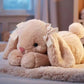 Plush rabbit toy with a bow on a bed in a bedroom setting.